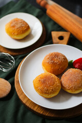 A handmade bombolone or bomboloni is an Italian-filled doughnut that is eaten as a snack or dessert. Selective focus.
