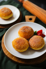 A handmade bombolone or bomboloni is an Italian-filled doughnut that is eaten as a snack or dessert. Selective focus.