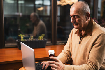 Senior man using laptop for online telemedicine consultation. 