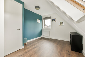 Bright, modern interior featuring a decorative teal wall, wooden flooring, and natural light pouring in through the windows, creating a serene atmosphere.