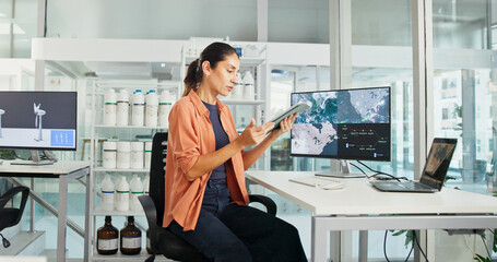 Computer screen, tablet and windmill with business woman in office for renewable energy or...