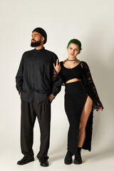 Stylish multicultural couple showcases contemporary fashion in studio setting