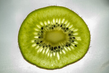 High-resolution macro shot of a kiwi slice, showcasing green translucent pulp