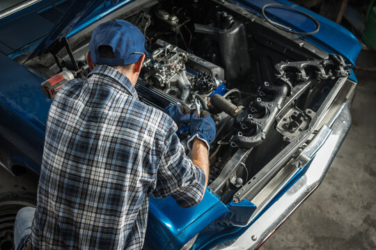 Car Mechanic Repairing Engine in Automotive Workshop