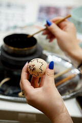 The process of painting Easter eggs, using bees wax as traditional Lithuanian method