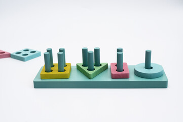 Montessori wooden sorting game with geometric shapes and stand on white background, featuring...