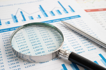 Magnifying glass on spreadsheet and graph paper. Financial data economy, Business.