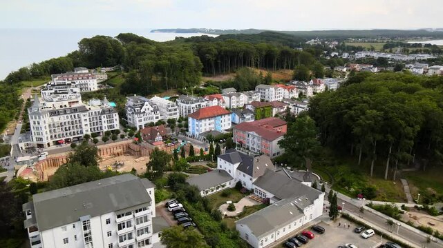 Aerial drone view of a charming coastal town on R&uuml;gen, nestled between elegant buildings, forest and the distant sea horizon.
