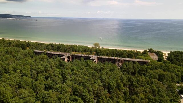 Aerial drone footage of abandoned buildings hidden in dense forest near the coastline of Prora, R&uuml;gen&mdash;mysterious and hauntingly beautiful.