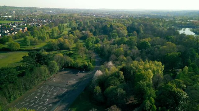 Reversing aerial of Ormeau Park in Belfast, Northern Ireland on a warm, sunny summer day. The camera passes over the park and tennis courts. Filmed in 4K, 60 frames per second and in Rec709 Color.