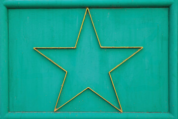 Fototapeta premium A richly textured background texture with vintage green tones and weathered golden star stylish and evocative of a bygone era.