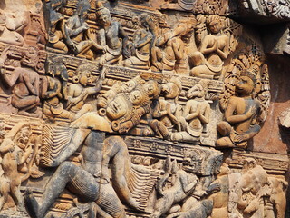 Ancient stone temple with detailed carvings and statues at the entrance
