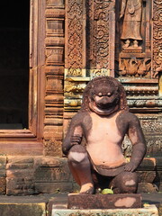 Ancient stone temple with detailed carvings and statues at the entrance
