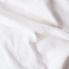 Natural white cotton linen fabric background. Soft plain textile top view surface earth tone color. Close-up texture of neutral white cloth for display products, mockups or presentations.