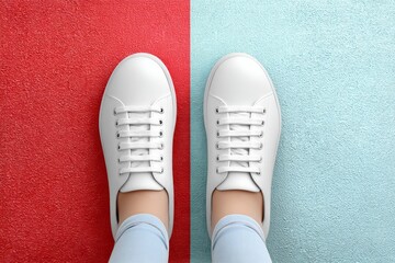 A clean design showing a pair of feet standing on a split road in opposing colors