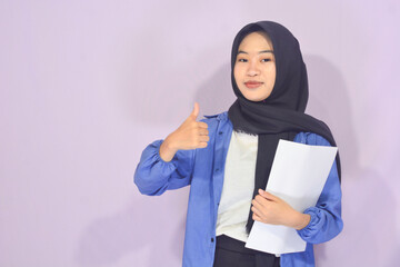 Concept of recreation, literature, A Muslim Asian woman holding a book, suitable for advertising