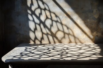 Sunlit stone table displays intricate shadow patterns from a window lattice