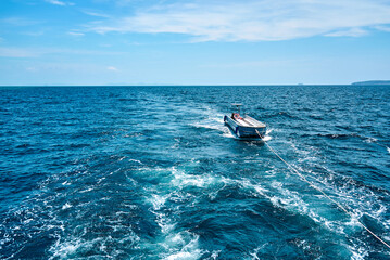 Towed fishing boat navigating calm blue waters