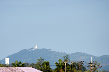 A beautifully serene landscape showcasing a distant hill adorned with a stupa, enveloped by lush greenery
