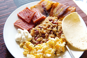Traditional Costa Rican breakfast, rice and beans, called Gallo Pinto with eggs, tortilla, sausage...