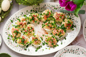Eggs stuffed with bacon and green onions on Easter background..top veiw
