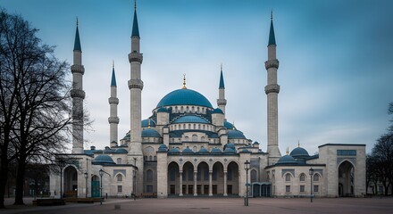 Obraz premium Grand Mosque Exterior with Minarets and Blue Dome Under Cloudy Sky