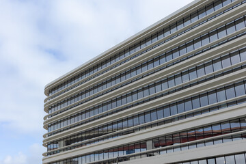 A sleek modern office building in Lisbon, Portugal, showcases clean architectural lines, a glass facade, and minimalist design, reflecting the blue sky and urban sophistication.