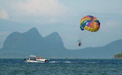 Semporna, Malaysia. On December 01, 2018, a tourist parachute flight by a guided boat over the sea waves.