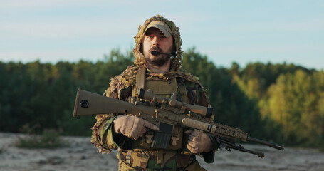 The soldier, wearing a moro uniform and helmet, has a focused and serious expression in this...