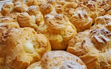 Light, airy cream puffs filled with luscious vanilla custard, dusted with powdered sugar. A delightful treat that melts in your mouth with each bite, perfect for any occasion.