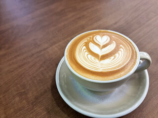 Close-up of a cup of hot latte art simple tulip coffee on wooden background.