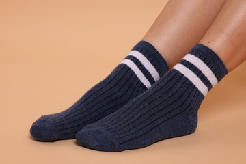 Woman in stylish socks on beige background, closeup