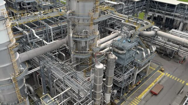 Panorama inside of the interior of a chemical plant or oil refinery. Pipeline structure, heavy equipment in process area. Steel tanks and boilers with cables, pipelines and valves for chemical mixing