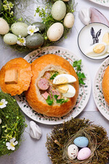 Traditional Polish Easter soup zurek served in a loaf of bread, smoked meats and egg..top veiw