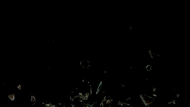 Broken glasses exploding against black background. Slow Motion.
