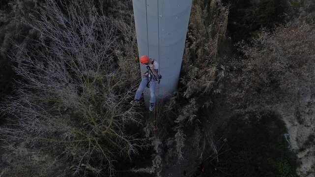 Technician performing rope access inspection on industrial column