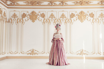 Elegant woman in lavish pink gown poses gracefully in opulent room with ornate details