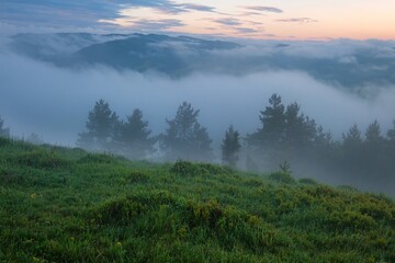 Mountain landscape with fog after rain, peaks in the fog. Beautiful, colorful spring panorama of Pieniny Mountains and Tatra Mountains in the fog and morning light, Poland, Slovakia
