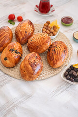 Freshly baked pastries with accompaniments. Selection of freshly baked pastries arranged on a woven mat. Selective focus.
