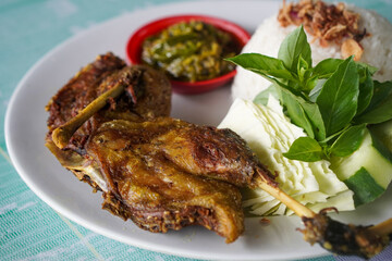 Indonesian fried duck, captured on April 16, 2025. Crispy on the outside and tender inside, served with rice, sambal, and fresh vegetables for a rich, savory meal