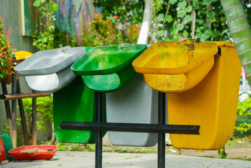 three recycling bins in various colors, Recycling bins in the flower garden area