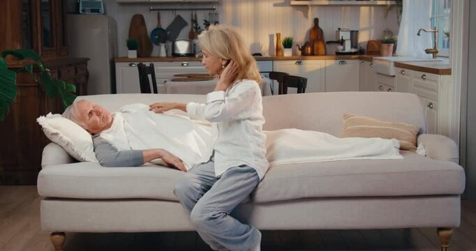 Mature woman caring about her sick old husband, man caught cold in autumn. Happy marriage and healthcare, seasonal viruses and disease of old age, stay healthy and active in retirement, aged spouses
