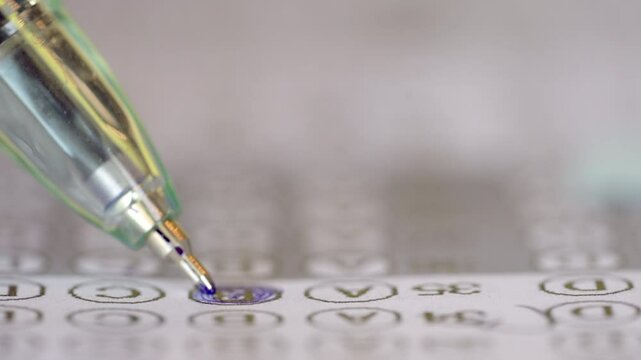 A pen is writing on a piece of paper. The pen is blue and has a black tip