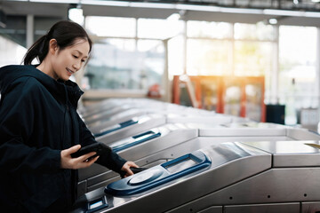 Modern Commuter Navigating Subway Turnstile with Smartphone