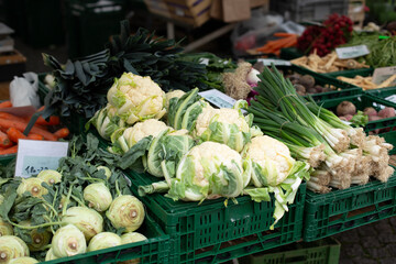 Counter with fresh vegetables and a sign of local products. 