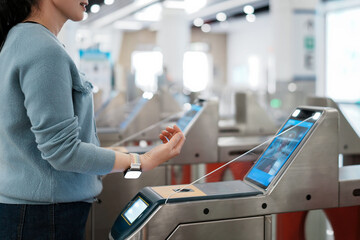 Woman Using Contactless Technology at Public Transportation Entry Point