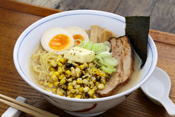 Japanese miso ramen noodles topped with grilled corn, butter, soft-boiled egg, roast pork, bamboo shoots and nori seaweed.