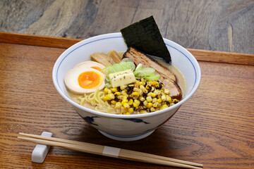 Japanese miso ramen noodles topped with grilled corn, butter, soft-boiled egg, roast pork, bamboo shoots and nori seaweed.
