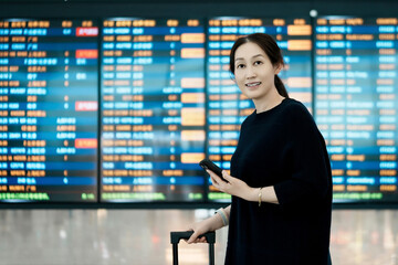 Fototapeta premium Woman at Airport Checking Flight Information with Smartphone