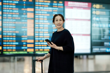 Fototapeta premium Modern Traveler Checking Flight Information at an Airport